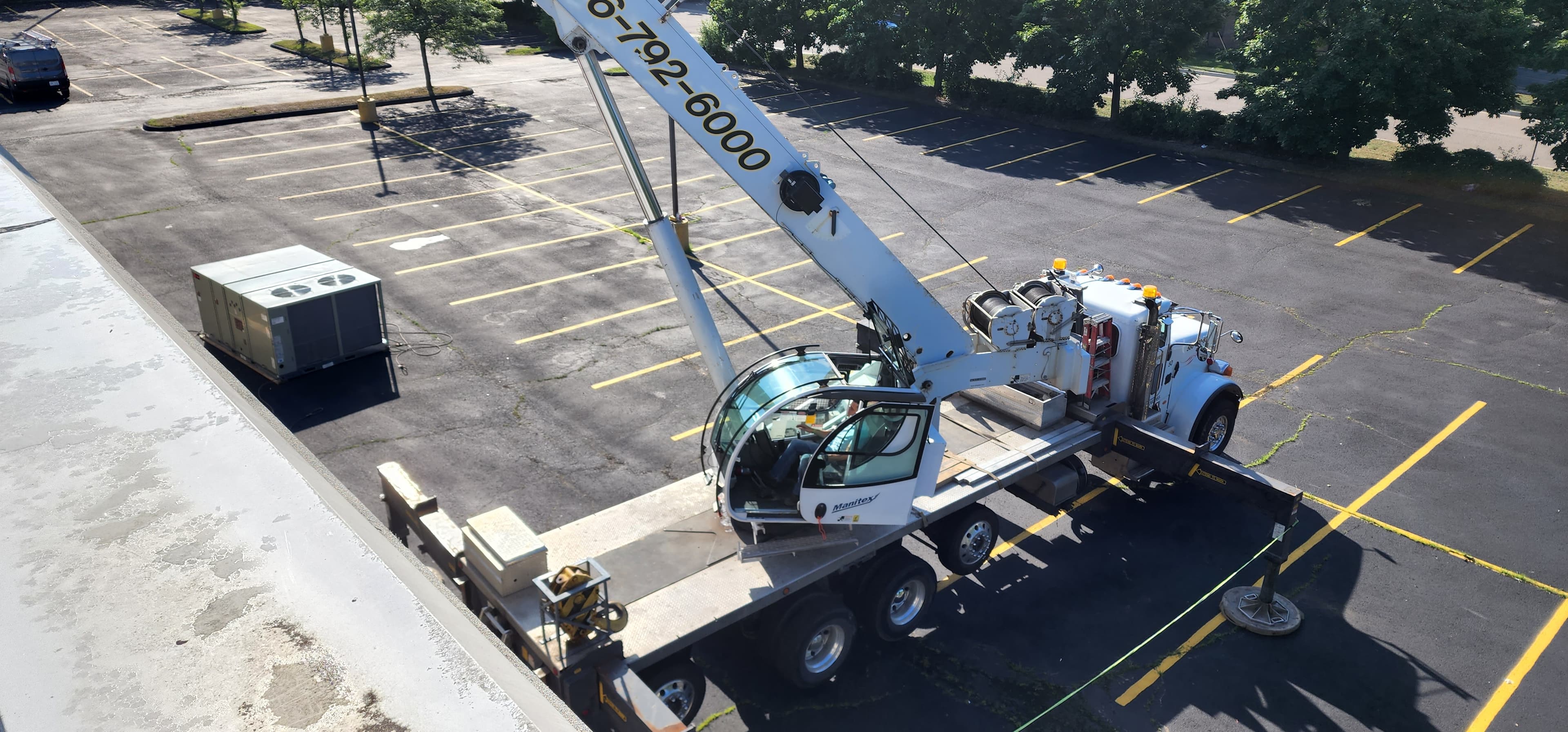 Crane operating during a rooftop HVAC unit placement