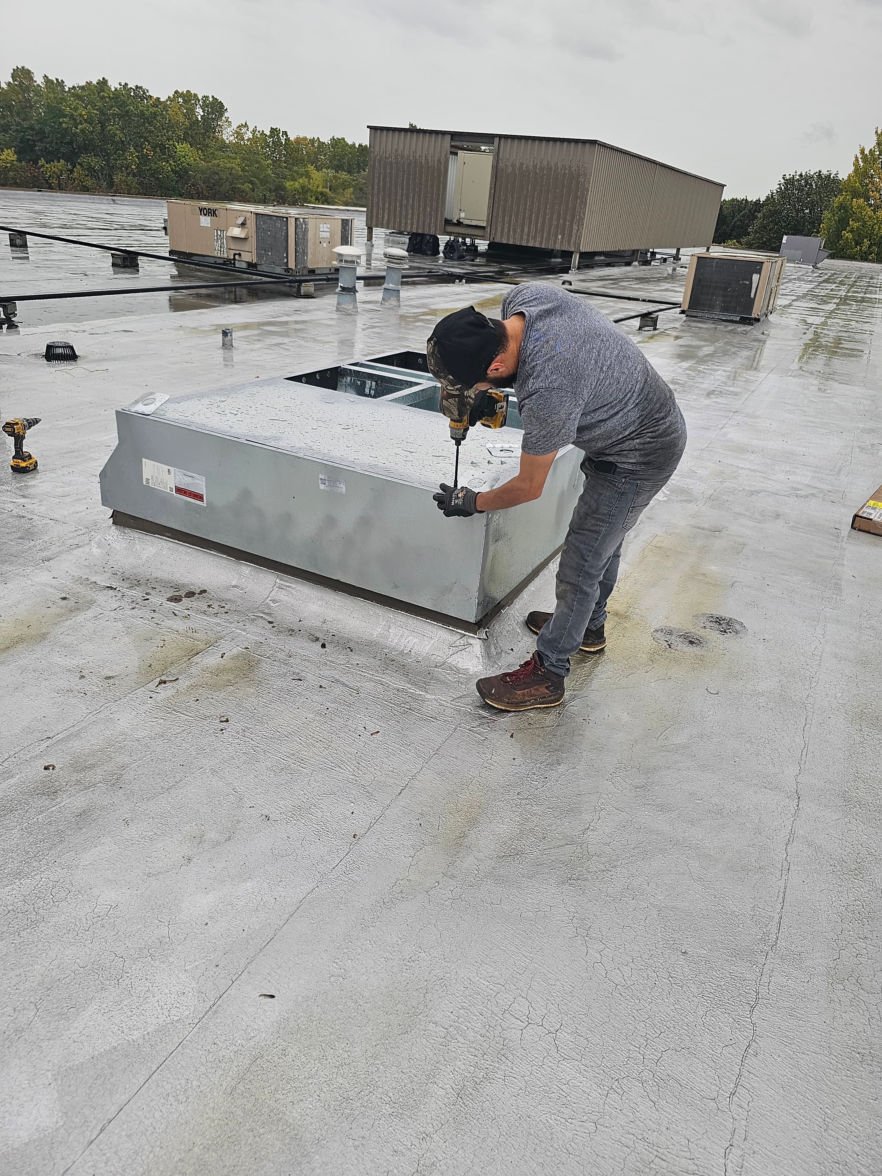 HVAC technician working on rooftop equipment during service