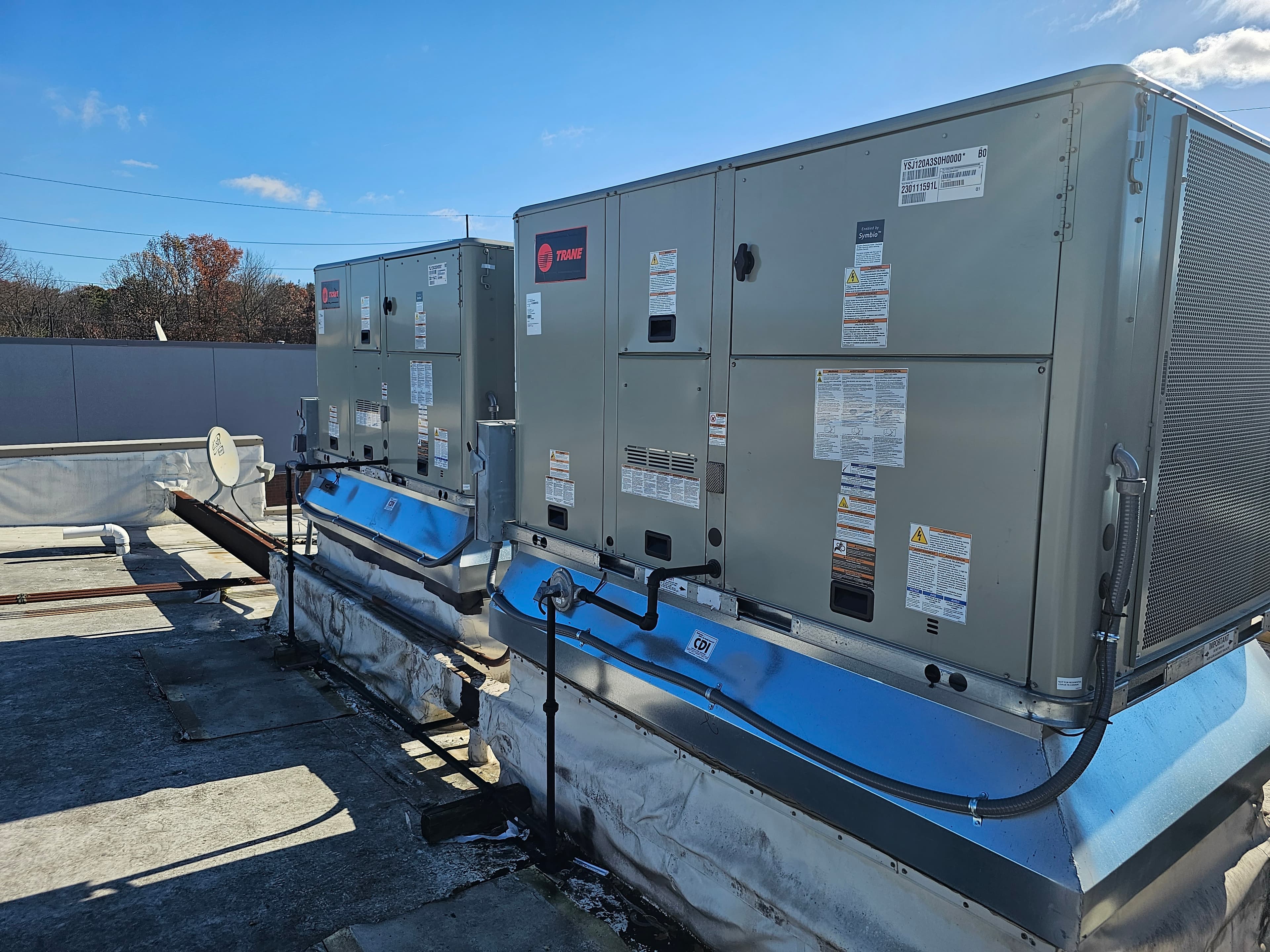 Two packaged rooftop HVAC units installed on a commercial roof
